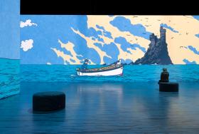 Une personne devant Tintin, l'Aventure immersive, avec un bateau sur la mer
